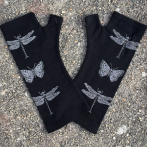 Beautiful black merino wool gloves with dragonfly print on the ground