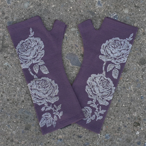 Beautiful purple merino wool gloves on the ground.