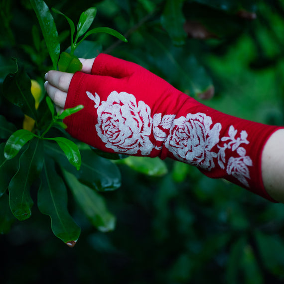 Lovely fingerless merino wool gloves on a womens hand touching a tree.