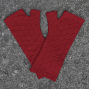 Lovely red textured merino wool gloves on the ground.