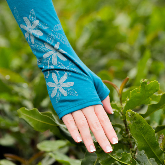 Georgeous Blue Gloves touching a young macadamia tree.